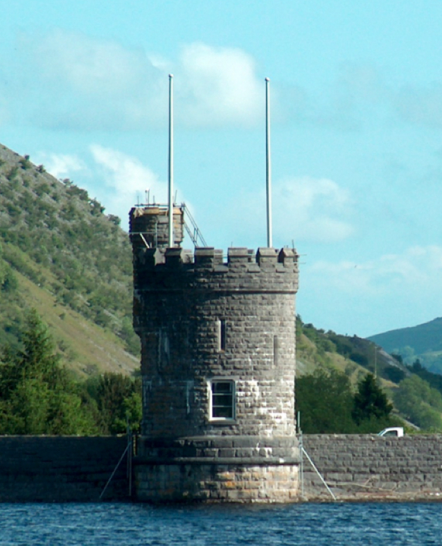 Two flag poles on a castle turret.